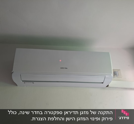 מזגן קיר לבן מותקן על קיר עם שלט אדום